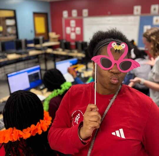 A student gets ready to pose for a selfie after writing code to program the camera.
